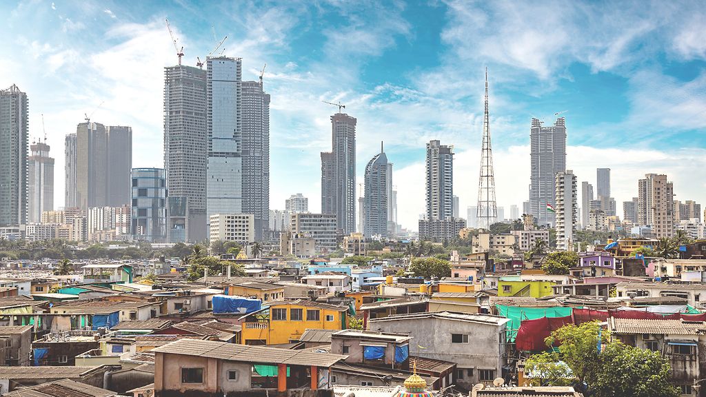 Views of slums on the shores of mumbai, India against the backdrop of skyscrapers under construction