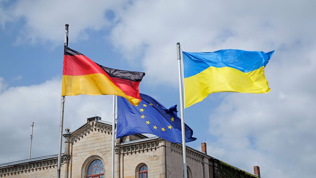 The flags of Ukraine, Germany, and the EU waving in the wind
