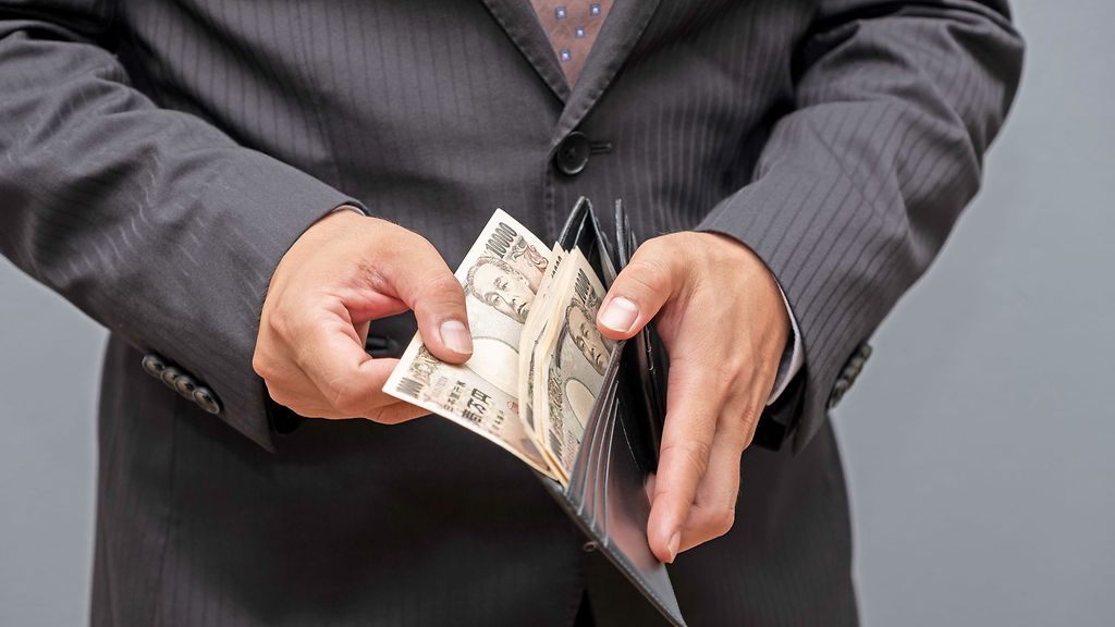 Business person gripping 10000 Japanese yen banknote from wallet, Earning and invesetment concept