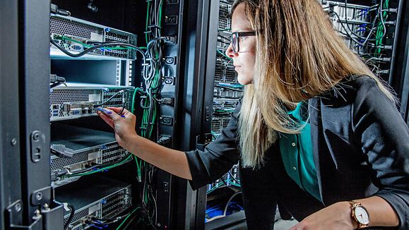 Female IT Engineer Working in Server Room.