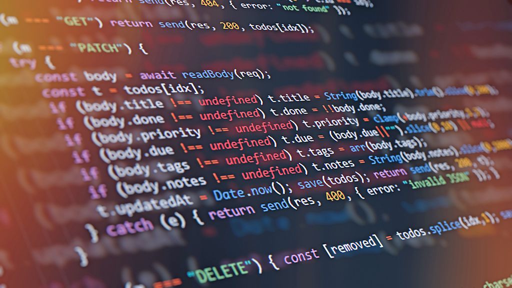 Close-up of computer screen showing colorful programming code lines with syntax highlighting and blurred light reflections. Abstract background representing software development, AI programming, machine learning, cybersecurity, and modern technology innovation. Perfect for illustrating digital transformation and data science concepts.