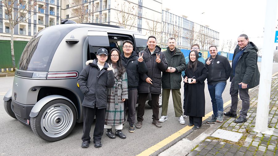 Mitarbeitende des Unternehmens Staff-Eye, darunter CEO Alexander Kovalenko, stehen vor dem autonomen Shuttlebus Pix RoboBus