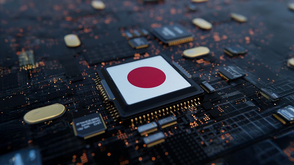 Nahaufnahme eines Computerchips mit der japanischen Flagge auf der Oberseite, eingebettet in eine dunkle Leiterplatte mit leuchtenden Schaltkreisen