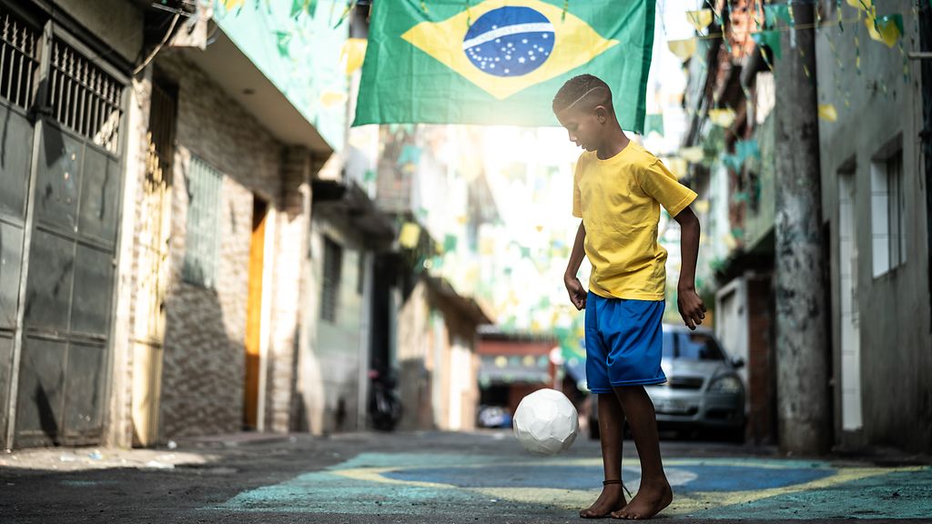 Brazilian Kid Playing Soccer in the Street