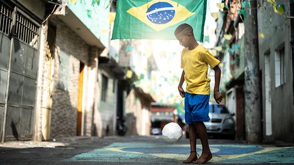 Brazilian Kid Playing Soccer in the Street