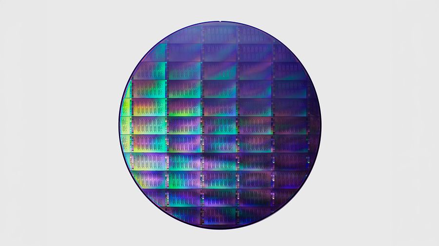 Runde, violett, blau und grün schillernde Halbleiterscheibe mit regelmäßig angeordneten Chipstrukturen für die Herstellung von Quantenchips.