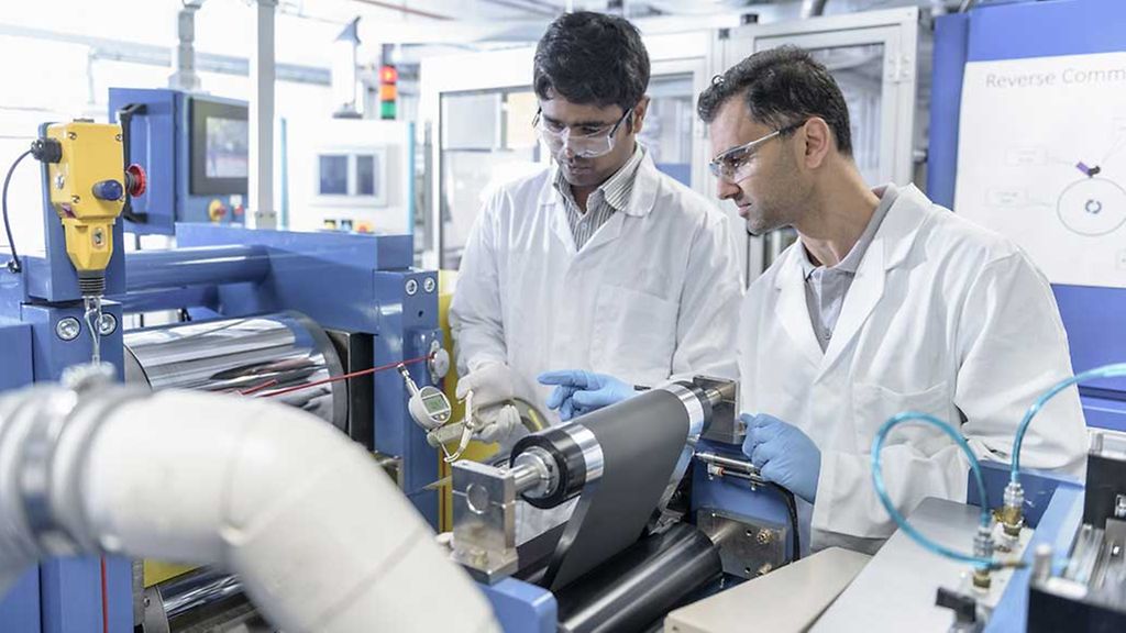 Scientists with lithium ion battery production line in battery research facility