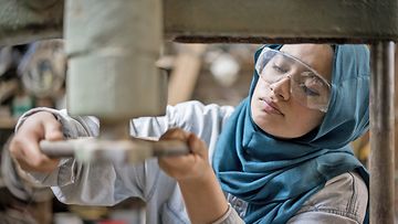 Muslim girl is working small family carpenter factory