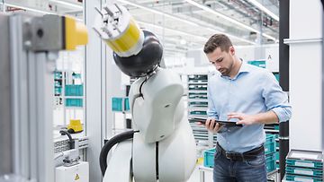 Industrie 4.0, Technologie; Roboter; Roboterarm; Fabrik; Mann mit Tablet