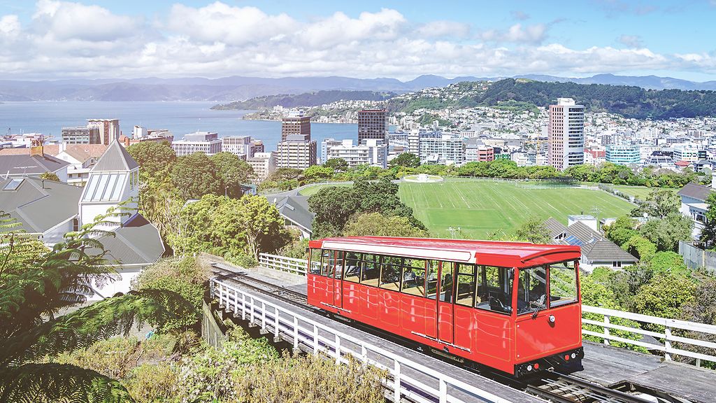 Wellington Seilbahn Red Trolley mit Downtown Wellington Stadtbild im Sommer unter blauen Sommerhimmel. Wellington, Nordinsel, Neuseeland, Ozeanien.