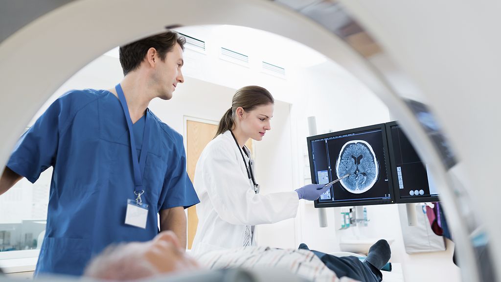 Two Doctors with Patient at CAT Scan. Slight motion blur.