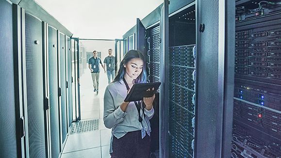 Frau mit Laptop vor Dastenservern