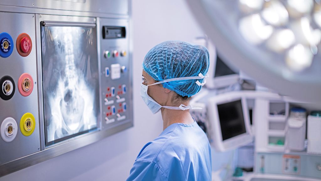 Female surgeon reading x-ray