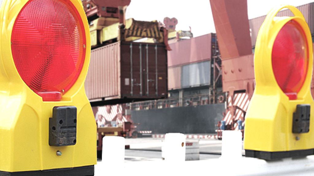 Symbolbild Handelsbeschränkungen: Warnleuchten vor Containerterminal | © iStock.com/tomac1, yangwenshuang Symbolbild Handelsbeschränkungen: Warnleuchten vor Containerterminal